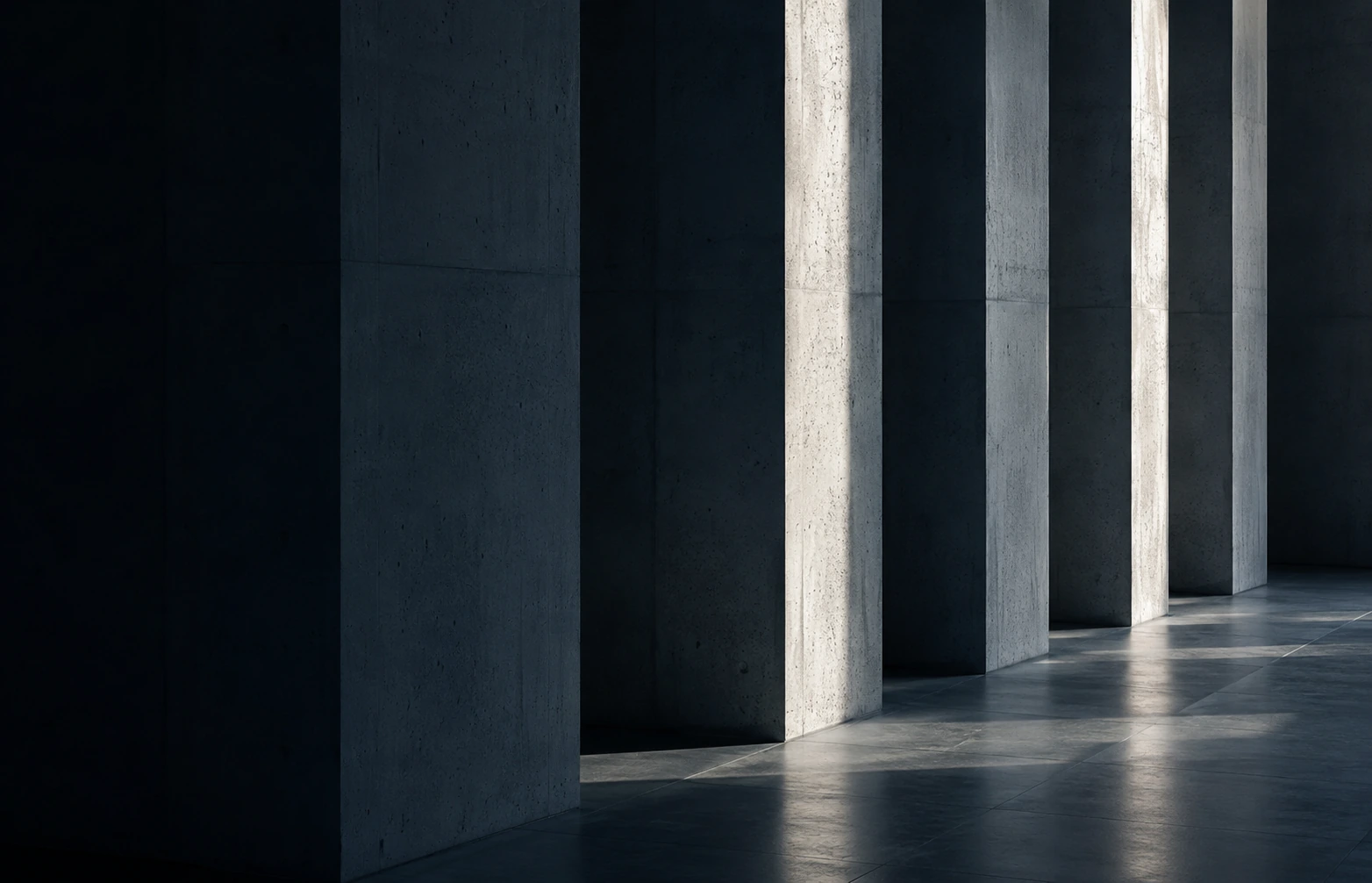 Daylight falling between a row of concrete columns in a quiet interior